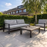 Loungeset met salontafel op terras van Kera Full Body Rome tegels onder berk en haag