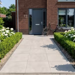 Pad van Kera Full Body Rome tegels 60x60x3 naar voordeur tussen buxushagen met fiets