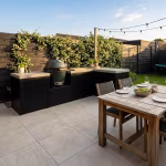 Buitenkeuken en houten eettafel op terras met Kera Full Body Rome tegels 60x60x3