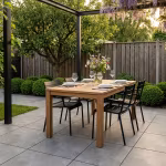 Gedekte houten eettafel onder pergola met blauweregen op Kera Full Body Turijn tegels