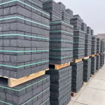 Hoge stapels BSS betonklinkers 8 cm op houten pallets op het terrein