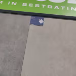 Showroomstaal Kera Rome keramische tegel met label onder groene banner