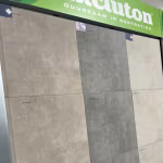 Showroomwand met keramische tegels in grijs en beige onder groene Excluton banner