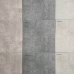 Showroomwand met grote keramische tegels in lichtgrijs, grijs en beige met kleine labels