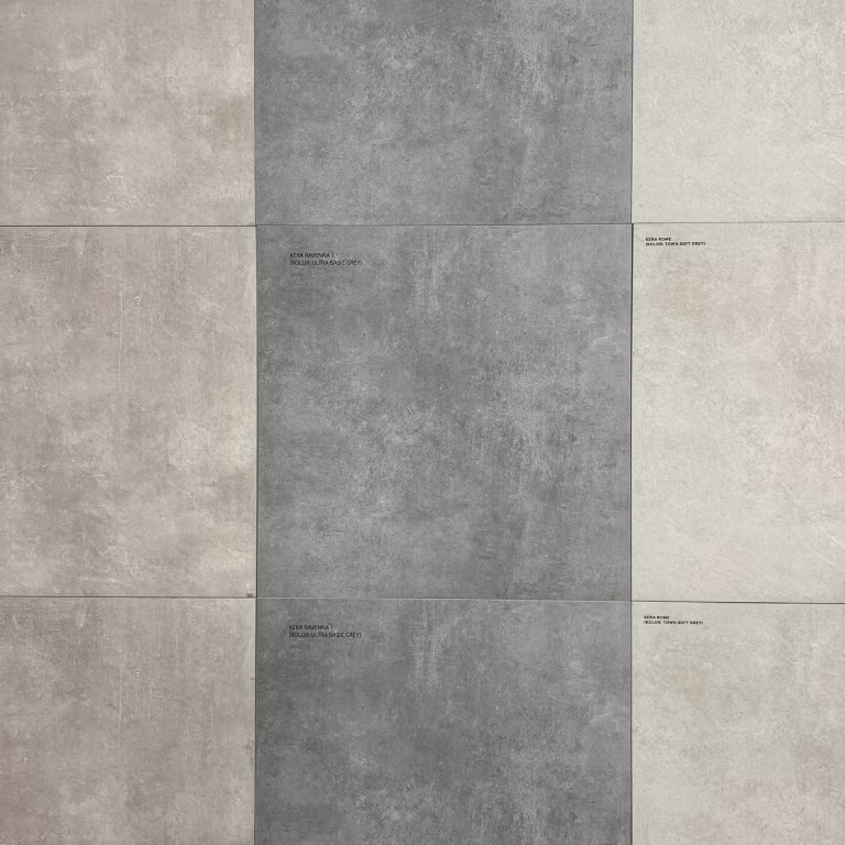 Showroomwand met grote keramische tegels in lichtgrijs, grijs en beige met kleine labels