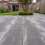 Terras van PromoStone 60x60x4 Grijs/Zwart tegels met gazon en tuinstoel