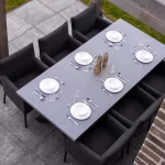 Bovenaanzicht gedekte eettafel met zwarte stoelen op GeoCorso Pescara tegels