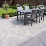Terras van WG Stone Trommelsteen 20x30x6 Taupe met antracieten tuintafel en stoelen