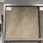Showroomstaal Season Claude 60x60x4 Sand in metalen rek met productlabel