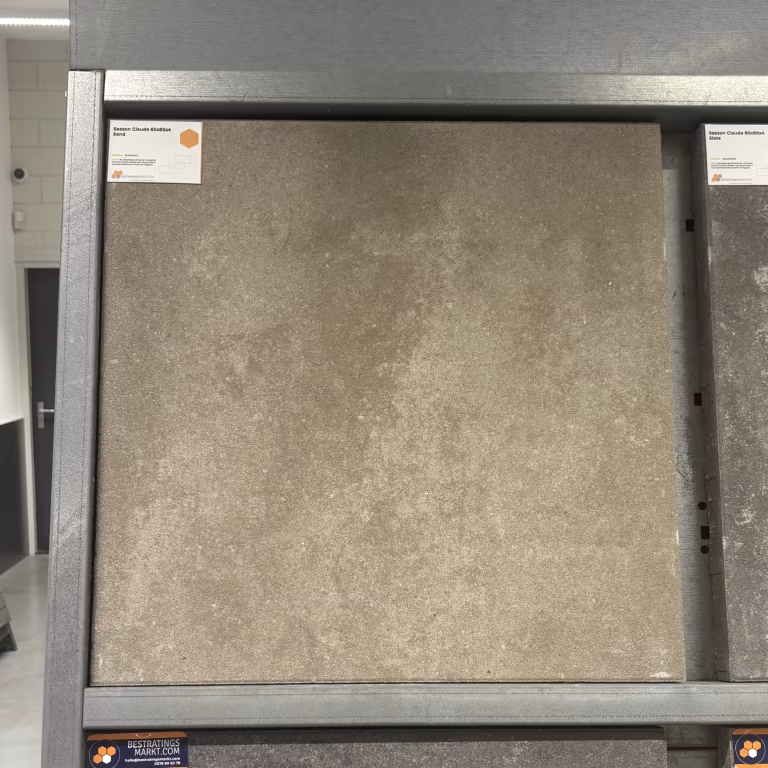 Showroomstaal Season Claude 60x60x4 Sand in metalen rek met productlabel
