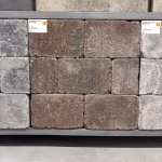 Showroomstaal bruine en grijze WG Stone Trommelsteen 20x30x6 in rek met artikellabels