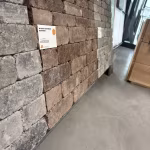 Showroomstalen WG Stone Trommelsteen bruin en grijs langs wand met label