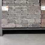 Showroomwand met gestapelde grijze WG Stone Trommelsteen 21x7x8 en artikellabel
