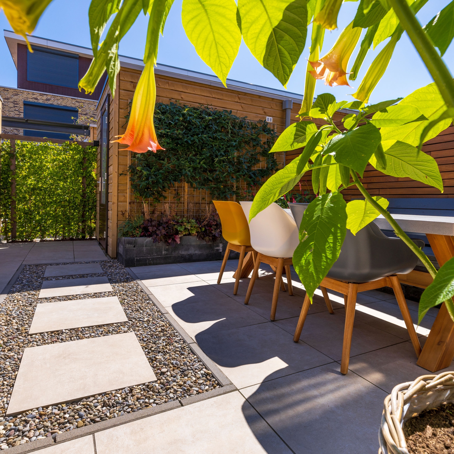 Modern terras met keramische tegels loungeset kleurrijke bloemen en grind