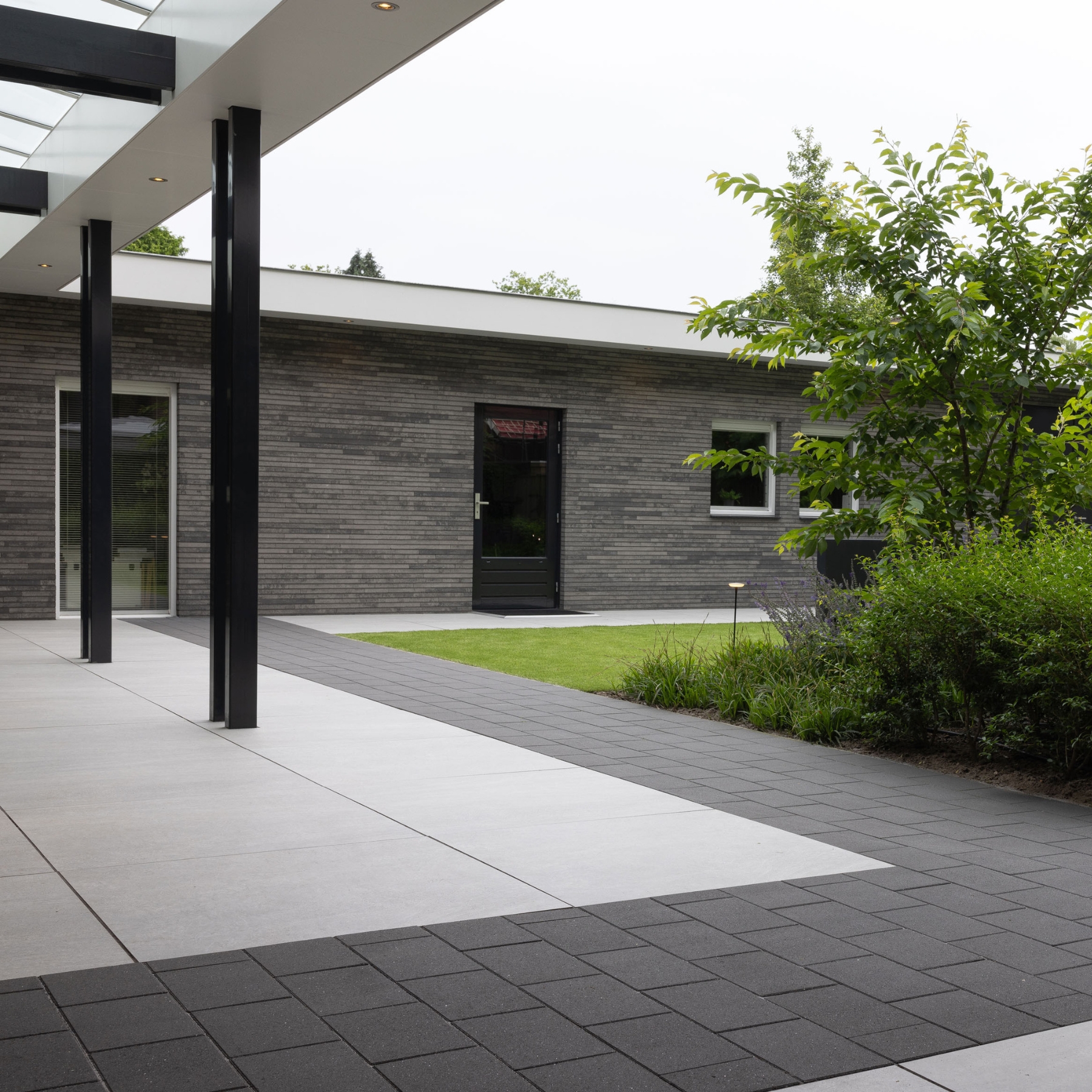 Modern terras en pad met combinatie van lichte en donkere tegels