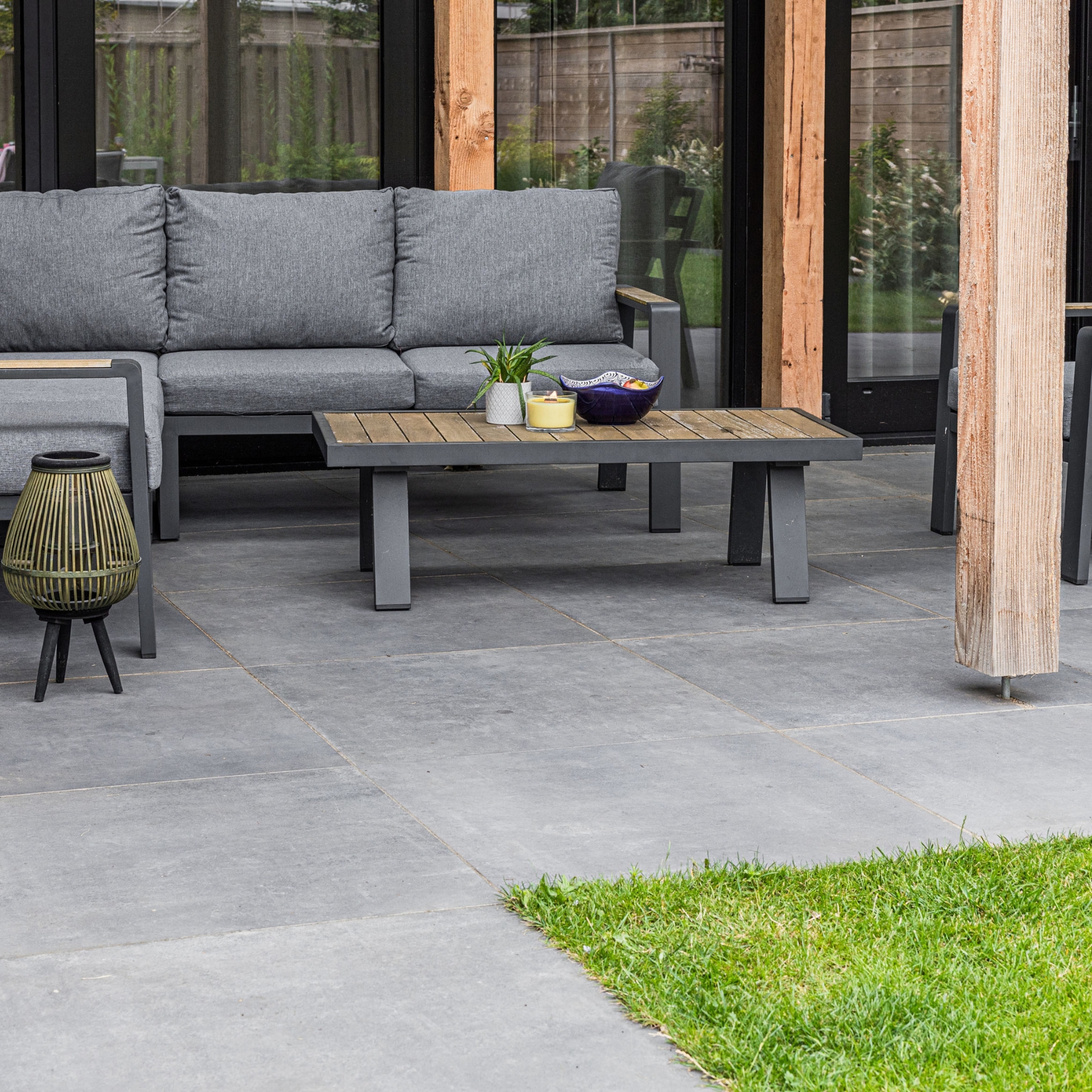 Antraciet keramische tegels met loungebank en tuintafel