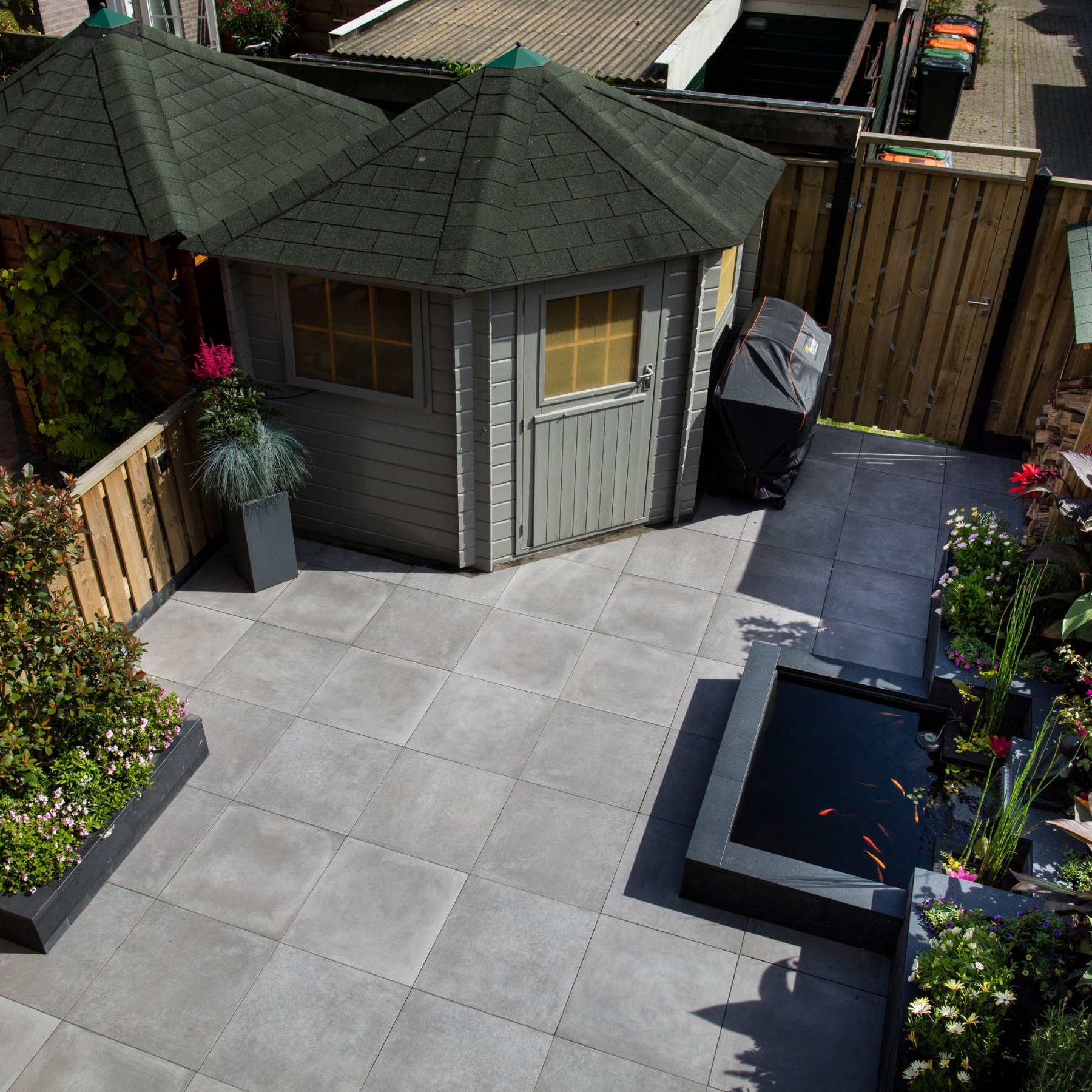 Bovenaanzicht complete tuin met keramische tegels en siervijver